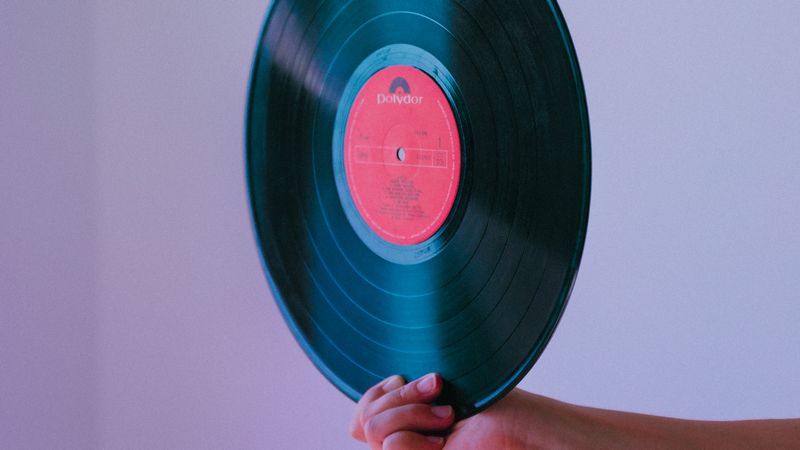 A hand holding a vinyl record